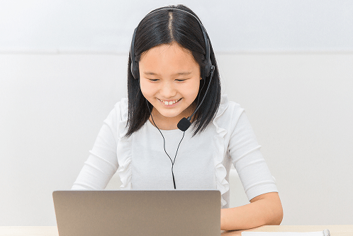 女の子がイヤホンをしてオンラインレッスンをしている